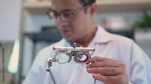 Ophthalmologist with optometrist trial frame in ophthalmological clinic, Optometrist checking trial frame in optical shop