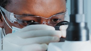 Ultra Macro Close Up Footage of a Male Scientist Wearing Medical Mask and Looking into the Microscope.