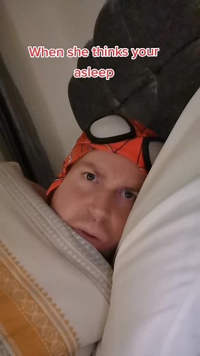 Humorous Close-Up: Spider-Man Mask Prank in Bed