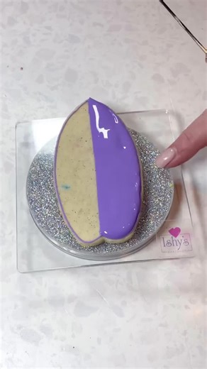 Nothing says summer like this Hawaiian print surfboard cookie! 🌞🏄‍♀️ To achieve this look, I use a wet-on-wet technique: start by drawing circles in the wet icing, then drag each circle to the center in four spots with a scribe tool. For the best results, clean the scribe between each pull to maintain a sharp and stunning pattern! 🌺 . #SummerCookies #HawaiianPrint #bakingtips #wetonwet #royalicingcookies