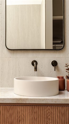 This bathroom by @rileylynchcarpentrydesign is a perfect example of the 60-30-10 rule in action 🤎 ✨ 60% is a dominant hue - ivory travertine wall tiles keep the bathroom feeling open and calm ✨ 30% is a secondary hue - natural timber in the vanity and terracotta peach floor tiles add depth and warmth ✨ 10% is an accent colour - Antique Brass tapware brings contrast and just the right amount of shine Would you try the 60-30-10 rule in your bathroom? Featuring @tilecloud Kirribilli Ivory Traverti