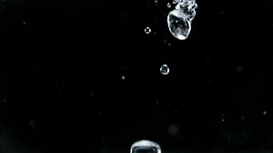 Download Water Bubbles Falling in Slow Motion on Black Background During the Day for free