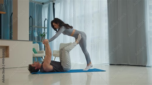 Man holding woman exercise trust together husband wife sport flexibility aerobics gymnastics active strong yoga balance health acroyoga acrobatic fitness pilates pose lifting female male training fly