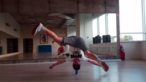 Man balances headstand on a single can
