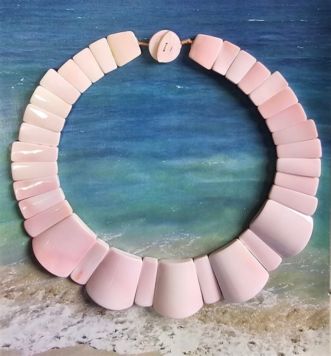 A 17-inch necklace of polished, flat queen conch shell beads with a conch shell circular toggle clasp. Comes with matching drop earrings of pink coral with gold-toned findings. Another creation from Christie's Collection of Honolulu, Hawaii. | Christie Adams