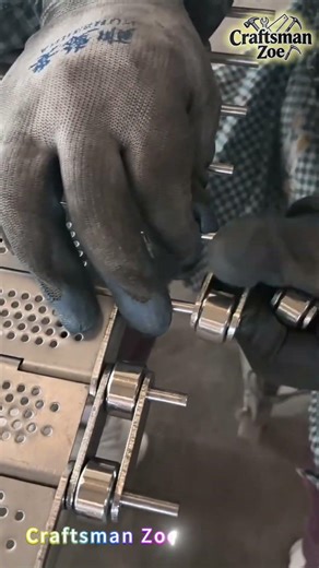 Workers install stainless steel chain plate components