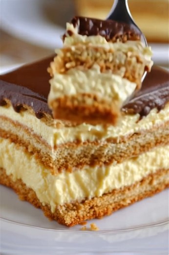 Eclair Cake! 🍫🍰 Layers of crisp graham crackers, creamy vanilla and cream cheese filling, and a luscious chocolate fudge topping create a no-bake dessert that tastes just like the classic pastry. It's a guaranteed crowd-pleaser! #EclairCake #NoBakeDessert #ChocolateDessert #VanillaPudding #GrahamCrackerCrust #CreamCheeseDessert #HomemadeDessert #SweetTreats #EasyDessert #ComfortFood #BakingLove #ClassicDessert #FamilyFavorite #PartyDessert #DeliciousRecipe #CoolWhipDessert #QuickDessert | Reci