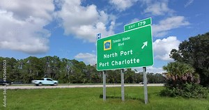 Highway interchange exit sign with direction to North Port and Port Charlotte in Florida. Interstate freeway travel in USA