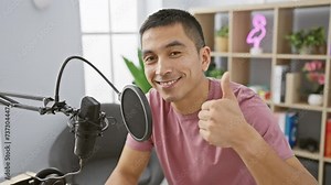 Cheerful young hispanic male flashing an 'a-ok' sign with a smile on his face in a radio studio