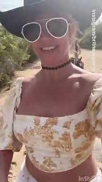 A TOPLESS Britney Spears goes horseback riding in the desert