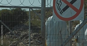 Ecology specialists in chemical protection suits entering the gate of landfill site to examing nature condition in toxc place.