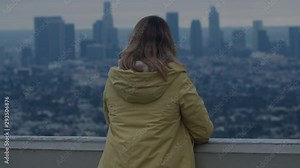 Back view of Caucasian female enjoying the view of of Los Angeles Downtown from Griffith observatory, all brand names and logos removed. 4K UHD