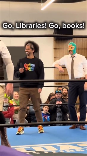 Mychal on Instagram: "Video Description: Mychal and a masked librarian wrestler stand inside the ring at the Vacaville Cultural Center Library, with Mychal saying, “Go, libraries! Go, books!” A @luchalibro_ referee is knocked out of the ring, and Mychal is asked to help by getting in the ring. He removes his Library Joy sweater to reveal a referee shirt. Mychal ‘emergency referees’ as chaos ensues before finishing moves are hit and he counts “1, 2, 3!” with the crowd to declare winners ✨ #Bookst