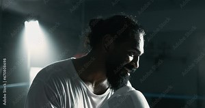 Profile close-up face of boxer inside ring staring at opponent in dramatic gaze and lighting covered in sweat with focused expression