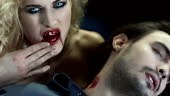 Slow Motion portrait of seductive vampire woman cleaning the blood of...