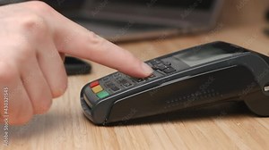 Close up man hand swiping credit card using POS terminal for payment.