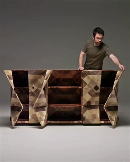 Design + Magazine on Instagram: "A credenza that feels alive with surface and gesture. Ark Cabinet by Adam & Arthur translates earthy tones and rhythm into sculptural form. Over 20,000 hand-dyed rye straw ribbons wrap a tessellated façade that shifts with light, making presence feel calm and deliberate. When closed it reads as monolithic calm. When open, three panels unfold with a pleated, origami gesture. Inside, straw marquetry continues, turning storage into celebration. 📐 @adamandarthur 🎥 