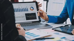 Two creative business people meeting and planning use post it notes sticky note on desk to share idea, Analysis data chart and graph with teamwork strategy brainstorming in office.