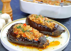 Μελιτζάνες γεμιστές με ρύζι και λαχανικά!! Υλικά: 3 μελιτζάνες Αλάτι, ελαιόλαδο 1 κόκκινη πιπεριά, 1 μέτριο κρεμμύδι 70 γρ. ελαιόλαδο 70 γρ. πελτέ ντομάτας 130 γρ. ρύζι Καρολίνα 300 γρ. βραστό νερό Πιπέρι, 1 κ.γ. κανέλα, αλάτι Μαϊντανός, 4-5 φύλλα δυόσμου 150 γρ. νερό Φέτες ντομάτας Πυρέξ 25x30 εκ. Εκτέλεση: Κόψτε τα καπάκια και χαράξτε τη σάρκα τους. Αλατίστε, λαδώστε και ψήστε στους 180°C για 30-40 λεπτά μέχρι να μαλακώσουν. Γέμιση: Σοτάρετε την πιπεριά, το κρεμμύδι και τη σάρκα της μελιτζάνας