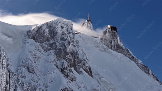 Snowy Aiguille du Midi peak and cable car in Chamonix France
