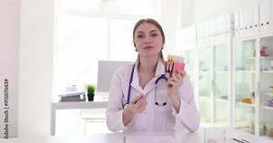 Woman dentist uses model of teeth to show signs of tooth decay. Doctor compares look of healthy tooth with diseased tooth slow motion