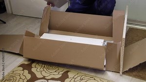 Unpacking the modular rack. The man opens the package and examines the wooden elements. Overall plan