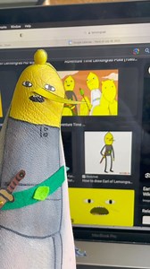 Such a magical request, thank you! I love finding new ways to fit characters onto my stump, keep those awesome ideas coming! I hope this brings a smile to your face, I love you to the moon! #cosplay #limbdifferenceawareness #lemongrab Video description: Alexis is sitting at a kitchen table, wearing a dark gray T-shirt. Her brownish, reddish, greyish hair falls and wavy layers around her shoulders. She is using black, white, yellow, and gray paint along with brown cardboard and green felt and one