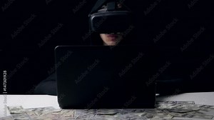 Hacker in the helmet of virtual reality work in dark room. He counts money. Cyber crime.