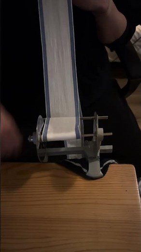 【柔道整復師】自宅で包帯の練習後、包帯を巻き直している何気ない瞬間（正面から）
