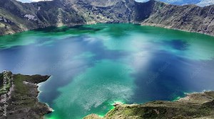 Incredible Quilotoa lake from volcano crater filled with water, Ecuador. Aerial forward