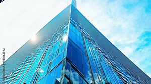Reflections of clouds on a modern glass building in the city during the day