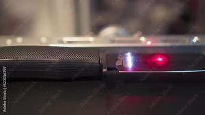 Laser engraving process camera passing by horizontally,feathers pattern on hunting knife surface, close-up, side view. Working laser on metal,workshop concept. Ray movement from handle to blade tip