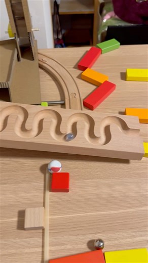 The marbles fall along a circular track, triggering a series of magical changes.
