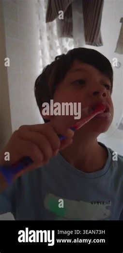Young boy cleaning teeth with focused expression expressing independence learning and healthy habit development within indoor setting Stock Video Footage - Alamy