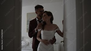 Bride and groom in wedding attire pose for flash photography in doorway