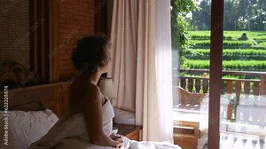 Close frame. The woman sits in silence and looks out the window wrapped in a blanket Sitting in silence in the morning helps you focus on the day ahead. Connect with your soul while sitting in silence