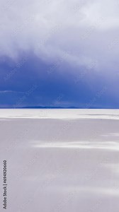 Uyuni Salt Flats. Salar De Uyuni. Aerial Hyper Lapse, Time Lapse. Altiplano, Bolivia. Dry Season. Dramatic, Stormy Sky. Drone Flies Sideways. Shadows Moving on Lake Surface. Vertical Video