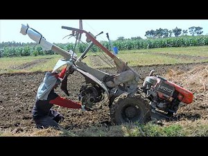Farmer Tilling Dirt Using A Diesel Hand Tiller Tractor