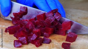 Cutting red beet root with sharp chef knife, macro shot, cooking process, preparing ingredients for eat. Close up of boiled beetroot, healthy lifestyle