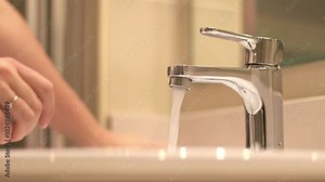 Bathroom tap, woman washing hands, close-up. Woman washing her hands over the sink in the bathroom. Personal hygiene. Washing hands under running water. Health care concept. Keeping hands clean