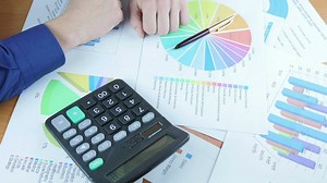 Person reviewing graphs on paper - Free Stock Video