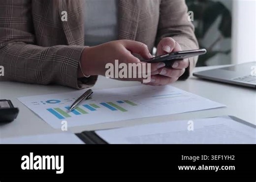 Businesswoman Analyzing Financial Data and Using Smartphone in Modern Office Stock Video Footage - Alamy