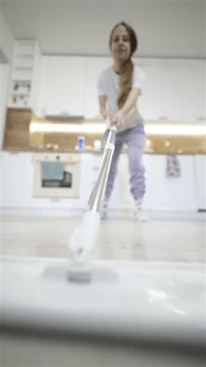 clip-4007271155-woman-cleaning-kitchen-mop-floor-near-modern
