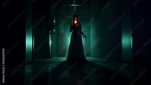 Zombie woman walking with burning candle in dark corridor. Creepy dead bride wearing wedding dress and veil. Bloody scary smile. Deceased fiancee returned to life. Halloween, usa holiday.