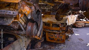 Rusty cars scattered on the ground next to a building