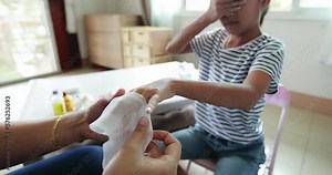Parent helping her child perform first aid finger injury.