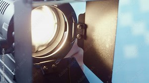 Cameraman installs and adjusts spotlight in studio. Professional photographer prepares equipment for better quality shooting