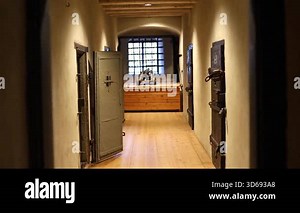 Dark stone prison inside a medieval castle, rusty bars, chains, and torch light illuminating the cold walls. Historical architecture and atmosphere of old confinement captured in 4K ultra HD.