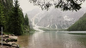 Lake between the mountains. Idyllic Lake Braies in the Dolomites. Italian landscape at day. Slow pan motion.