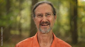 Happy man portrait of ethnic male looking at camera and talking on a video chat outdoors.